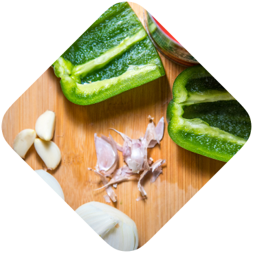 Green pepper, garlic and onion on a chopping board
